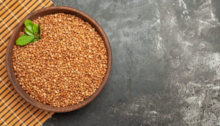 overhead-view-buckwheat-groats-with-green-brown-bowl-brown-tray-gray-background overhead-view-buckwheat-groats-with-green-brown-bowl-brown-tray-gray-background