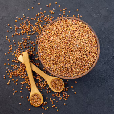 top-view-brown-buckwheat-inside-plate-with-pair-spoons-dark-background_179666-17377